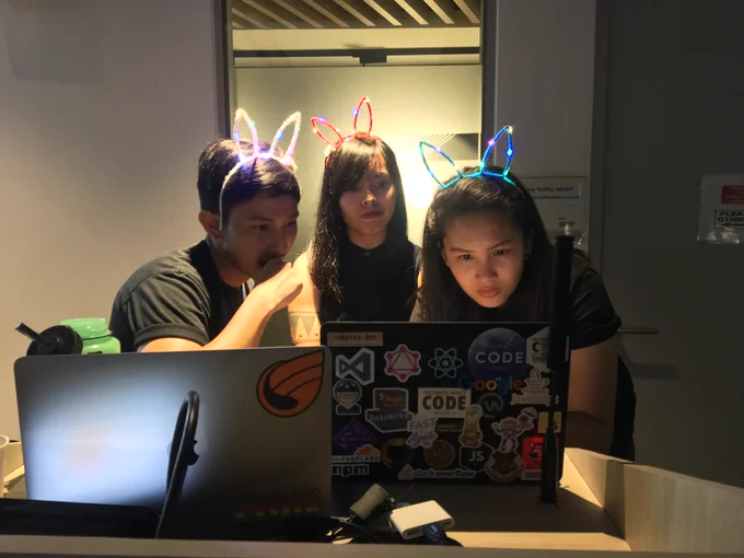 women who code in the dark 2019 organizers crouching over laptops