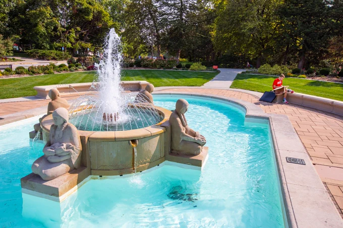 A student studies near the Fountain of the Four Seasons.