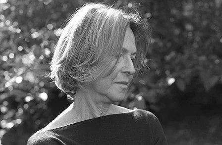 Profile photo of Louise Glück in front of trees.