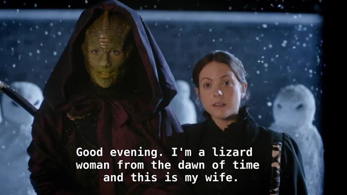 Madame Vastra (a reptilian) and Jenny, her wife, at a door. Vastra says "God evening. I'm a lizard woman from the dawn of time and this is my wife"