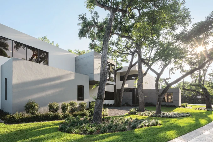 Sporting an exterior of selected blue-gray hues, granite cladding and stucco, the reinforced concrete structure is nevertheless a warm haven for the family of five inside.