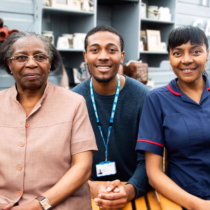 Louis, Blanche and Andrea sitting together on a bench at their trust.