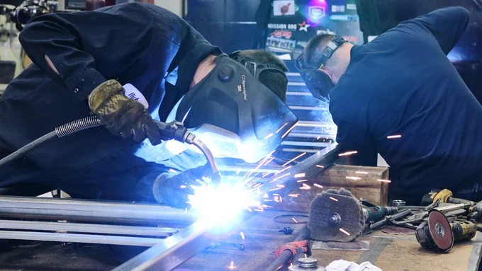 Two welders work on a welding project. 