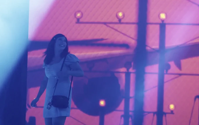 A girl walks through a projection screened airport