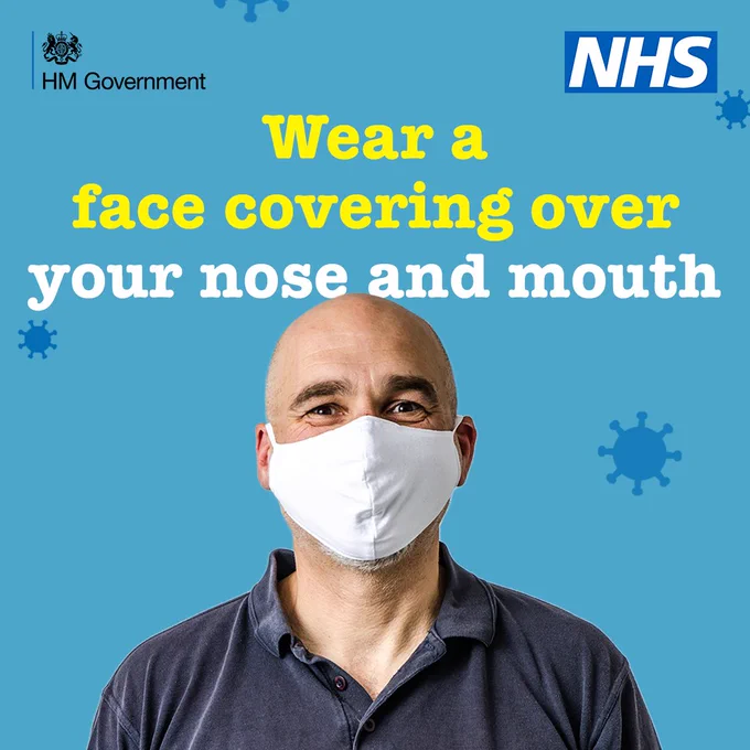 Bald man wearing a face covering over his nose and mouth. Text reads 'Wear a face covering over your nose and mouth'.