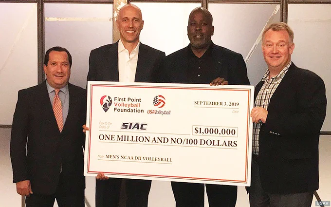 Four men standing with a giant check
