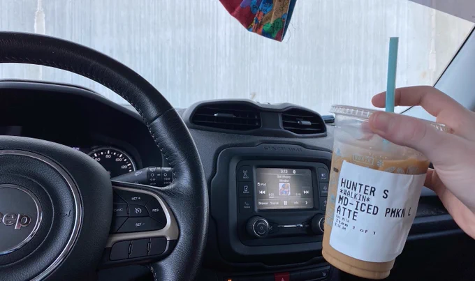 A coffee cup held up inside a car 