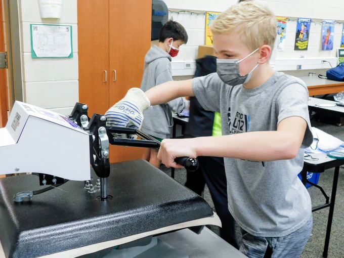 Boy using T-shirt press to make custom mask