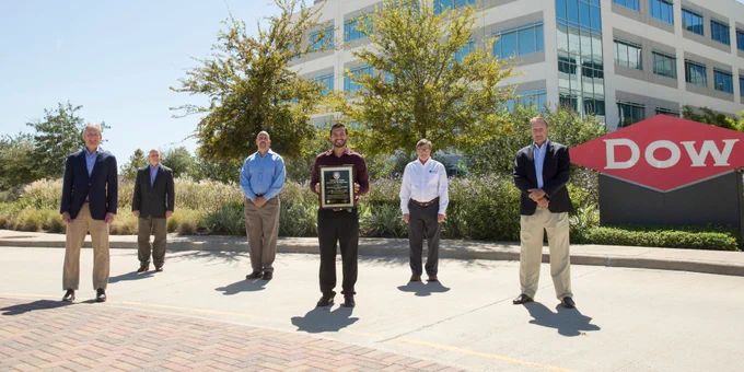 Dow Texas Operations colleagues stand in front of the Texas Innovation Center campus to display the FieldComm Group Plant of the Year award.