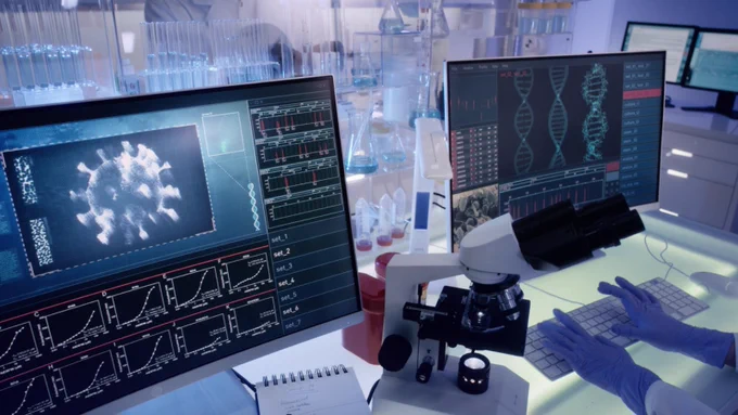 Two computer screens with charts looking at studying viruses. 