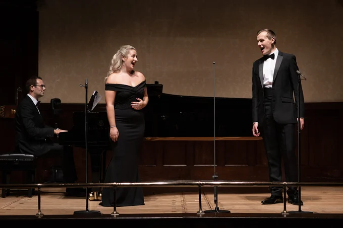 Christopher Glynn sits at the piano. Samantha Quillish and Glen Cunningham sing together on stage at the Wigmore Hall.
