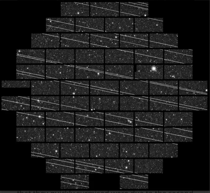 Similar to other image but with black background and more than 15 diagonal bright stripes due to satellite trails