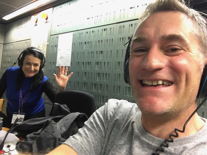 Gareth and Ghislaine, co-hosts of BBC Digital Planet in the studio. Smiling and waving at the camera