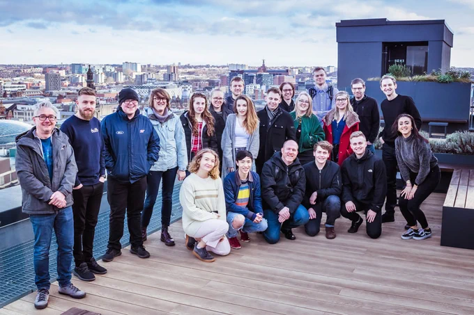 Group of people on a roof smiling.