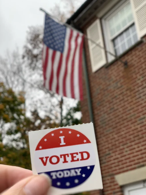 “I voted today” sticker in front of American flag.