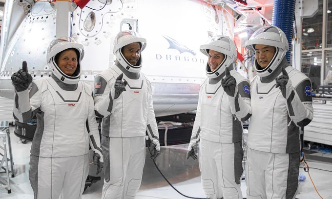SpaceX Crew-1 astronauts in flight suits pose for group portrait in front of Dragon spacecraft