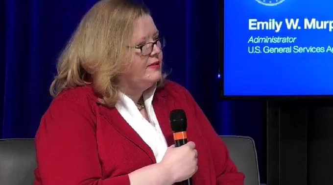 Administrator Murphy speaking onstage with microphone. 