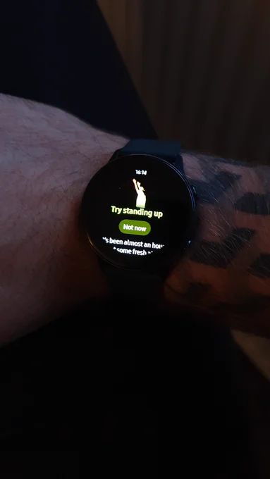 Smart watch with the words 'Try standing up' on the screen.