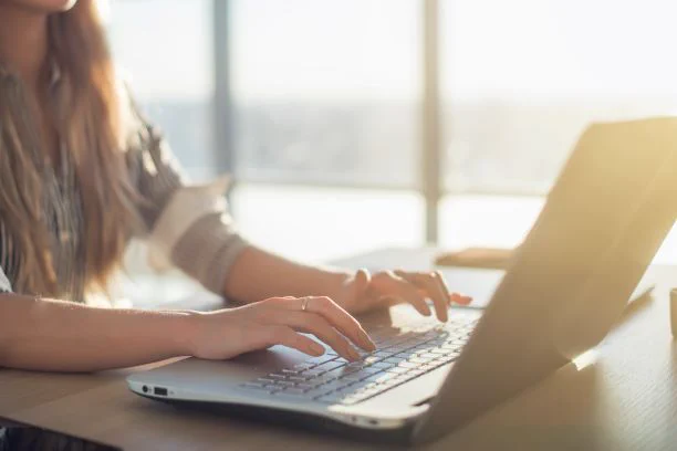 woman typing at laptop.