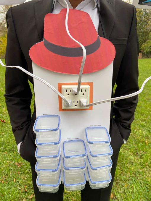 The clouds and on-prem data center are connected together to a power bar sitting on a set of Tupperware containers, and topped with a Red Hat logo (ie. "powered by containers and Red Hat")