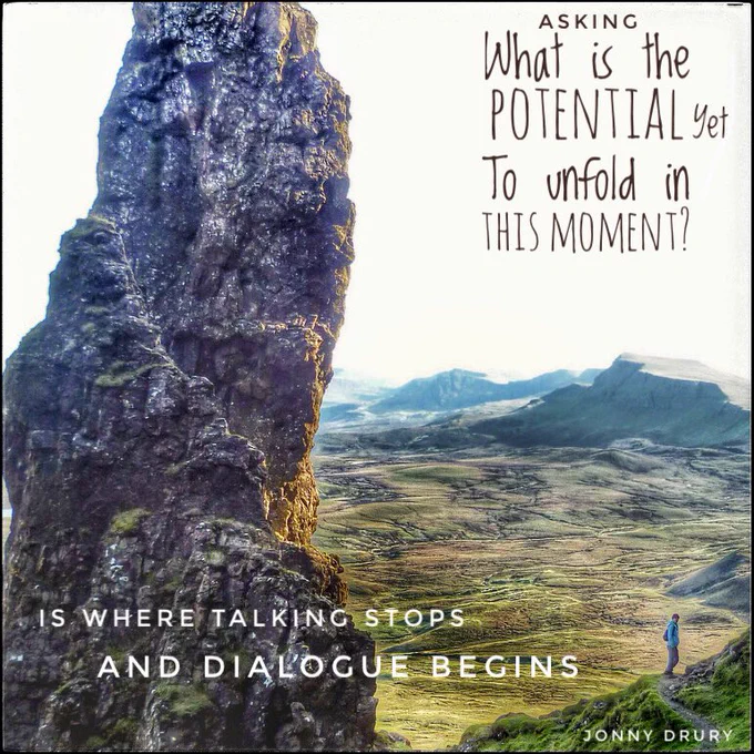 On the Isle of Skye, Scotland. A towering obelisk like rock (called Old Man of Storr) on the left foreground and fields, mountains and sea scenery on the middle and right and a walker in the right-side mid-foreground on a ledge path looking back at the camera. Overlaid text same as the tweet text.