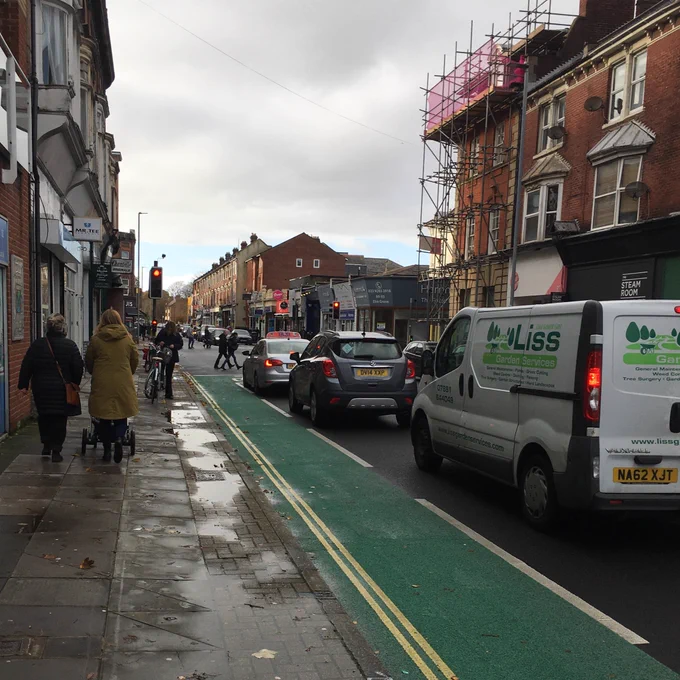 Looking west down Elm Grove past lines of traffic waiting at the lights. The paltry 25mstrip of unsegregated cycle lane that leads to the lights is in the foreground.