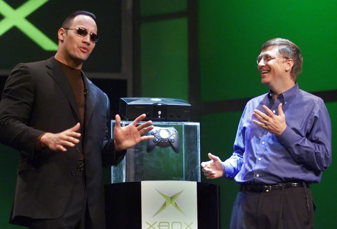 Dwayne “The Rock” Johnson and Bill Gates onstage premiering the original Xbox console in 2001.