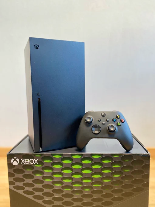 Xbox series X junto a su mando sobre la caja de la consola.
