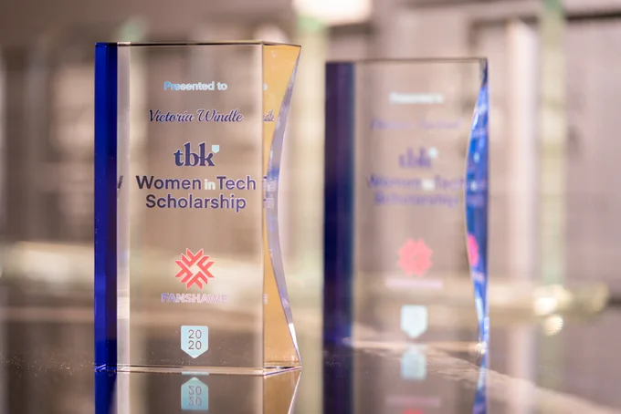 tbk's 2020 Women in Tech Scholarship trophy on a table; Victoria Windle, the 2020 recipient's name, inscribed on it.