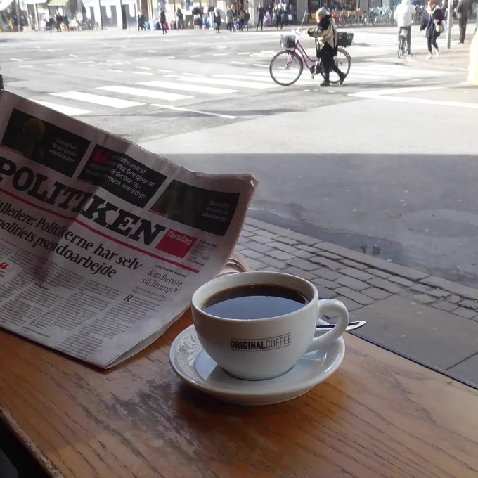 Cup of black coffee at Original Coffee in Copenhagen, next to a newspaper and street in the background. Photo by coffeediff.co.uk