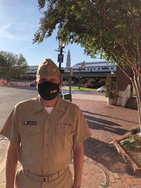 Franklin Foil poses for a photo wearing his black LSU-branded face mask along with his Navy uniform.