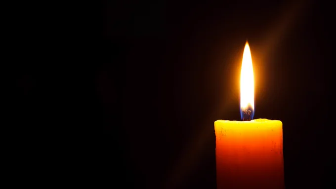 a single candle burning in the dark