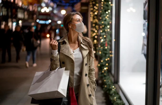Shopper wearing face covering looking in shop window