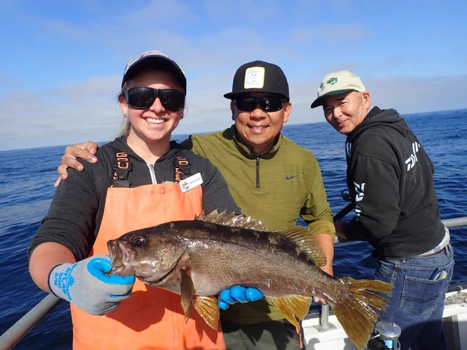Team member holding fish.