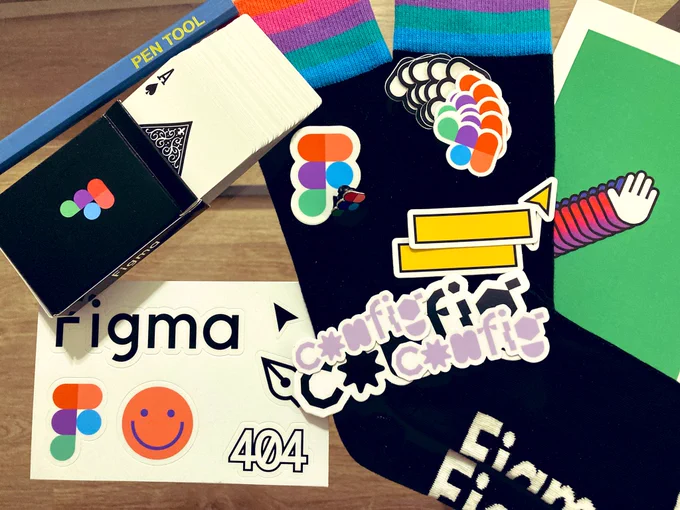 Photo with some gifts from Figma. Pencil, pin, stickers of various sizes and shapes, socks and a card deck.