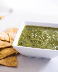 a picture of tomatillo salsa and some tortilla chips that look tasty