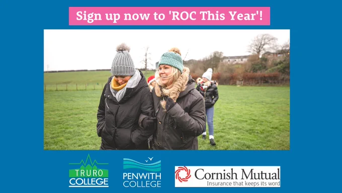 A family are out walking in the countryside. They are wearing hats, scarves, gloves and coats.