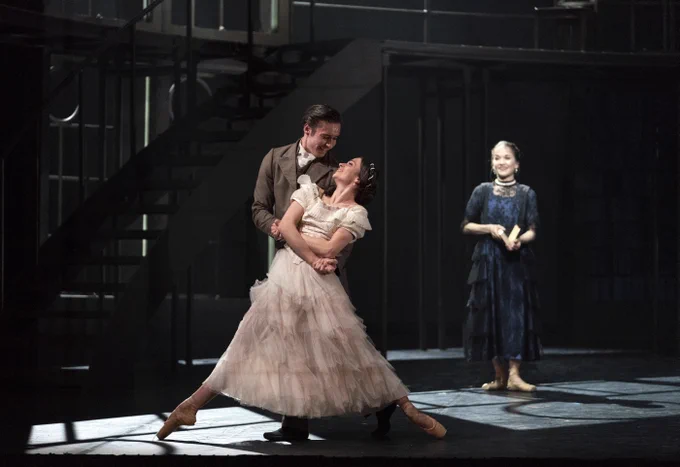 Three dancers perform as Prince Albert, Queen Victoria and Princess Beatrice. Prince Albert is holding Queen Victoria as she slides with her feet pointed, they are looking at each other happily. Princess Beatrice watches in the background.