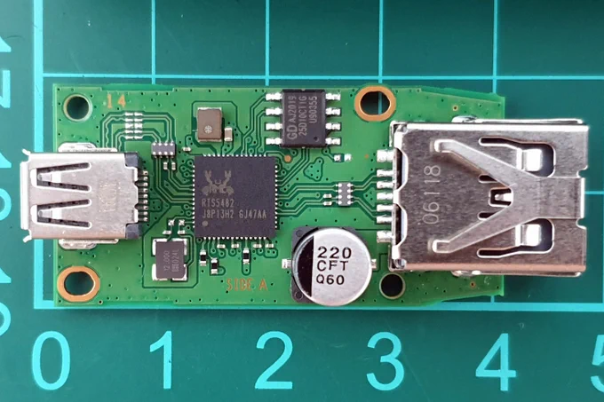 Giga Device - GD25D10 - SPI NOR Interface Flash, 1Mbit, 3V
Realtek - RTS5482 - USB2.0 Hub controller similarly found in the Playstation Classic MB