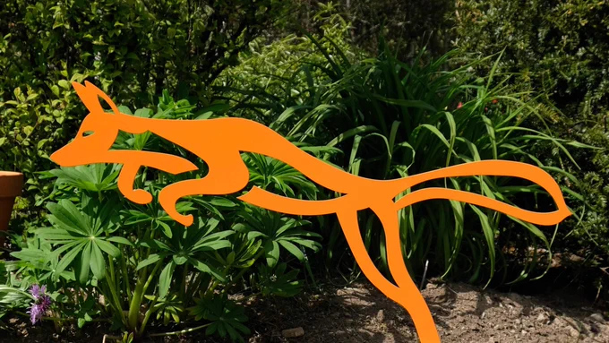 Metal sculpture in the shape of a pouncing fox