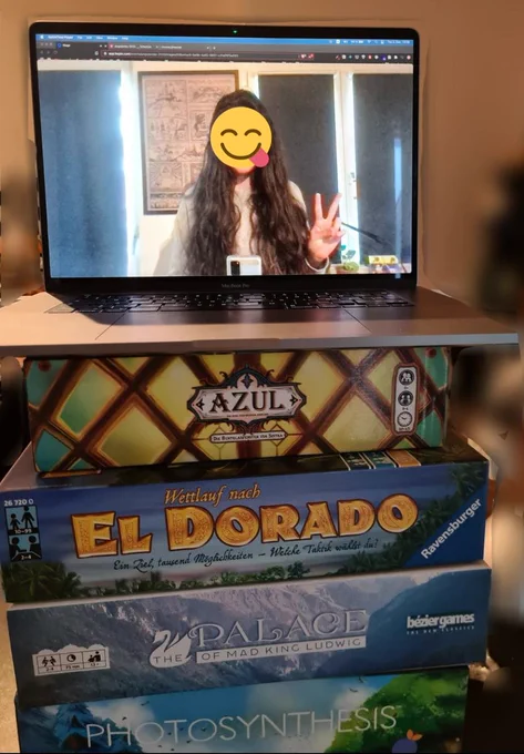 Laptop on top of a lot of board games