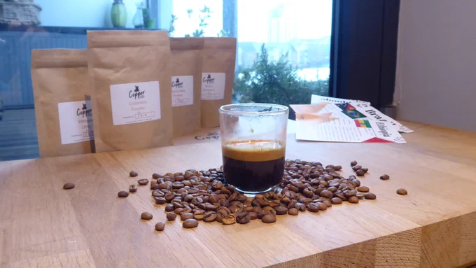 Espresso shot surrounded by coffee beans, featuring Copper Coffee Roasters. Photo by coffeediff.co.uk
