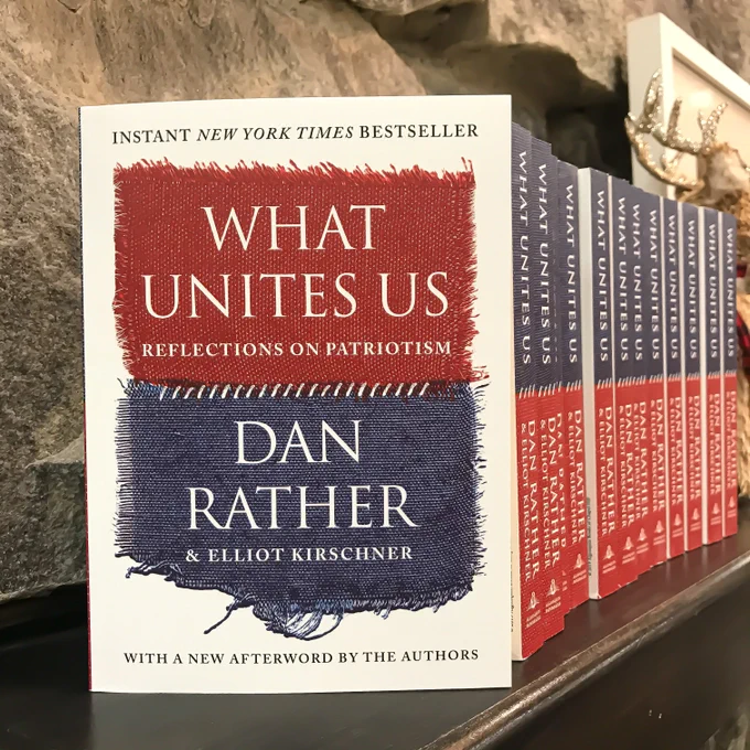 A shelf at Phoenix Books Burlington containing multiple copies of Dan Rather’s book, What Unites Us