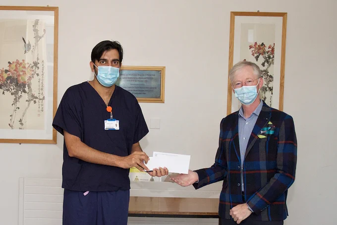 Dr Rajesh Kumar accepting the JS Prichard Award from Professor Joe Keane on behalf of the recipient Dr Richard Szirt.