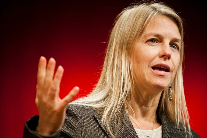 Dava Newman with her hand raised like she's speaking to an audience. 
