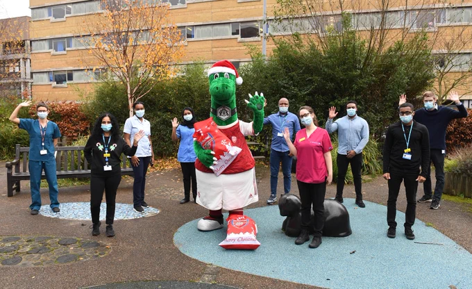 Gunnersaurus poses for a socially-distanced photo with NHS staff outside a local hospital