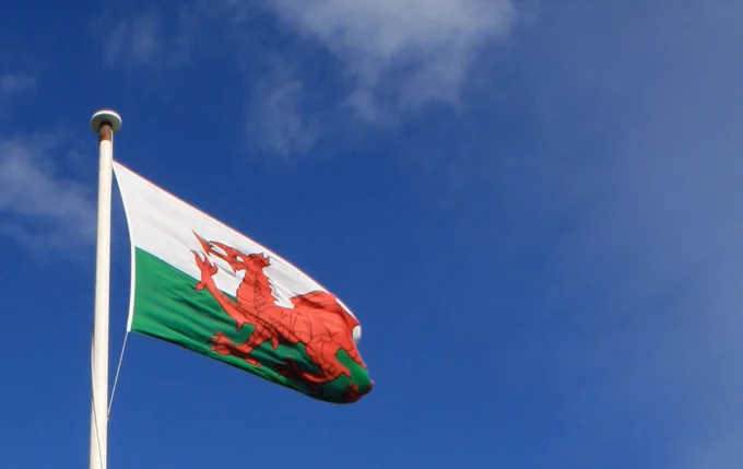 Welsh flag flying with blue sky background