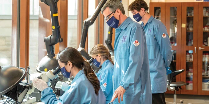 Prof. John Rogers works with students in his lab in the Technological Institute.