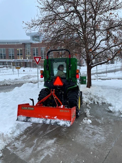 Christina Estrada, Grounds Maintenance Worker, clearing the area in front of Lawlor Events Center and the E. L. Wiegand Fitness Center from snow.