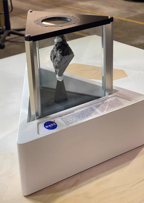 Glass display case holding Moon rock, with NASA insignia and information on base